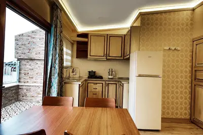 a kitchen with a table and a white refrigerator at Katelya Hotel in Istanbul