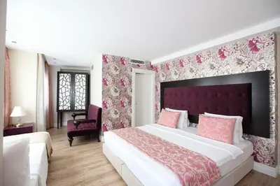 a bedroom with a large bed with pink floral wallpaper at Katelya Hotel in Istanbul