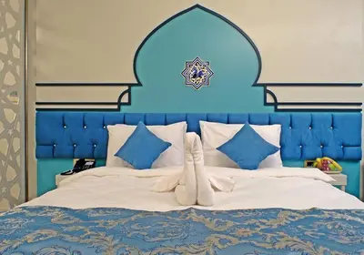 a large bed with a blue headboard and white sheets at KRALICE HOTEL in Istanbul