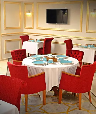 a dining room with tables and chairs and a tv at KRALICE HOTEL in Istanbul
