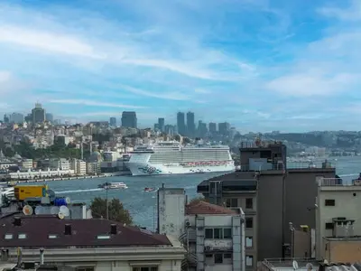 a cruise ship in the water in a city at Meserret Palace Hotel - Special Category in Istanbul