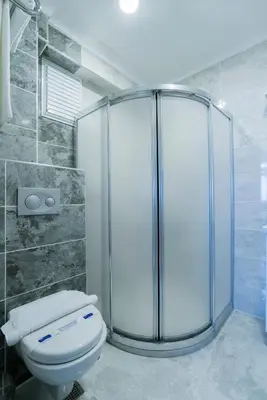 a bathroom with a glass shower and a toilet at ATAM HOTEL in Istanbul