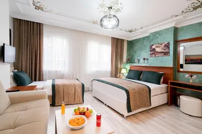 a hotel room with two beds and a couch at ATAM HOTEL in Istanbul