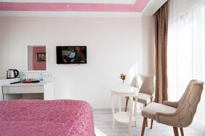 a bedroom with a pink bed and a table and chair at ATAM HOTEL in Istanbul