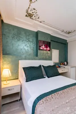 a bedroom with a white bed and a green wall at ATAM HOTEL in Istanbul