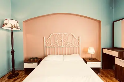 a bedroom with a white bed with a large headboard at Cheers Midtown Hostel in Istanbul