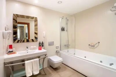 a bathroom with a sink and a toilet and a tub at Ramada Plaza by Wyndham Istanbul Atakoy in Istanbul