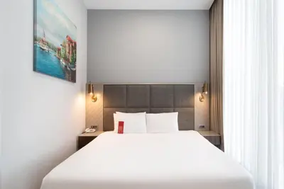 a bedroom with a large white bed and a window at Ramada Plaza by Wyndham Istanbul Atakoy in Istanbul
