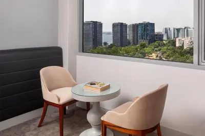 a room with two chairs and a table and a window at Ramada Plaza by Wyndham Istanbul Atakoy in Istanbul