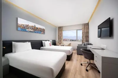 a hotel room with two beds and a desk at Ramada Plaza by Wyndham Istanbul Atakoy in Istanbul
