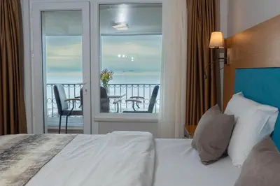 a bedroom with a bed and a balcony with a table at Seatanbul Hotel in Istanbul