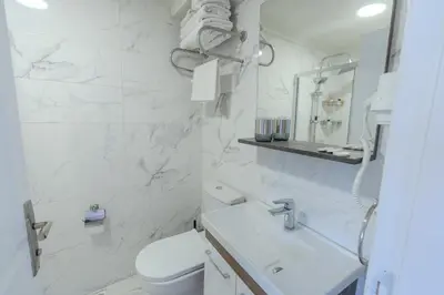 a white bathroom with a toilet and a sink at Seatanbul Hotel in Istanbul