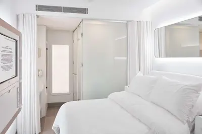 a white bedroom with a white bed and a window at YOTELAIR Istanbul Airport, Duty free - International Transit area in Istanbul