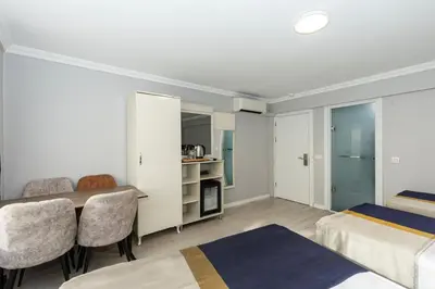 a bedroom with two beds and a table and chairs at Sirkeci Grand Family Hotel & SPA in Istanbul