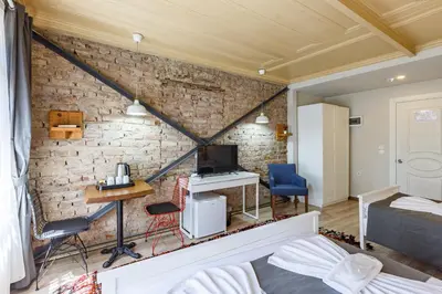 a bedroom with a brick wall with a bed and a desk at Hotel Miro Mansion Old City in Istanbul