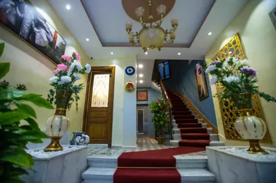a lobby with stairs and a chandelier and flowers in vases at The Void Hotel in Istanbul