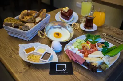 a table with a breakfast of eggs and food on it at The Void Hotel in Istanbul