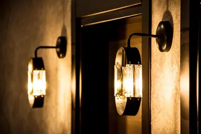 two lights on a wall with a mirror at Hit Suites Avcilar Hotel in Avcılar