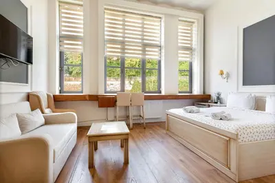 a living room with a bed and a couch and windows at Cezayir Rooms in Istanbul
