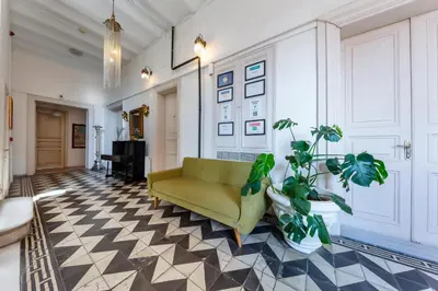 a living room with a yellow couch and a checkered floor at Cezayir Rooms in Istanbul