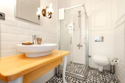 a white bathroom with a sink and a shower at Cezayir Rooms in Istanbul