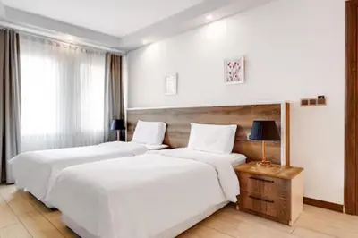 two beds in a hotel room with white walls at Yankı Hotel in Çekirge