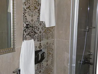 a bathroom with a shower and a white towel at Hotel Coliseum in Istanbul