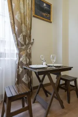 a wooden table with two wine glasses and a chair at Capricorn by Otantik Suites in Istanbul