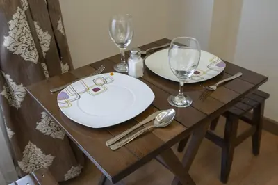 a wooden table with plates and wine glasses on it at Capricorn by Otantik Suites in Istanbul