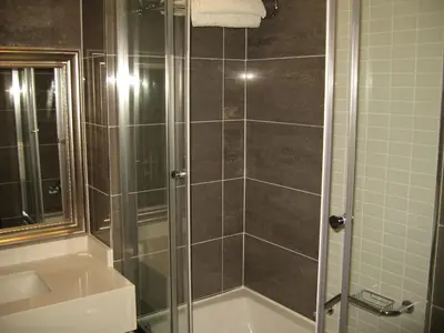 a shower with a glass door in a bathroom at Termal Elit Hotel in Gokcedere