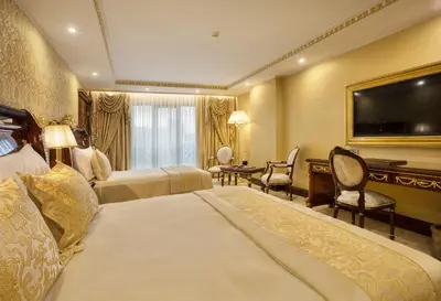 a hotel room with two beds and a flat screen tv at Ottoman's Life Hotel Deluxe in Istanbul