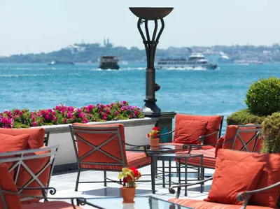 a patio with chairs and a table and the water at Four Seasons Hotel Istanbul at the Bosphorus in Istanbul