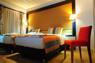 a hotel room with a bed and a red chair at Ottopera Hotel in Istanbul