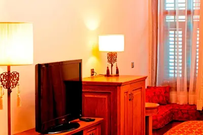 a living room with a television and a lamp on a cabinet at Celine Hotel - Ottoman Mansion in Istanbul