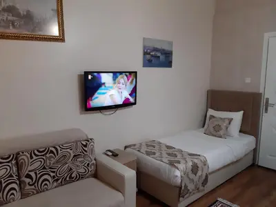 a bedroom with a bed and a tv on the wall at Burak Apart in Istanbul