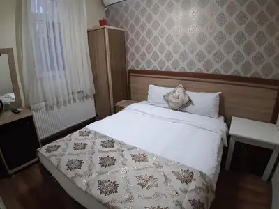 a bedroom with a bed with a white comforter at Burak Apart in Istanbul