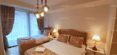a bedroom with two beds and a large window at Taksim leylak suite in Istanbul