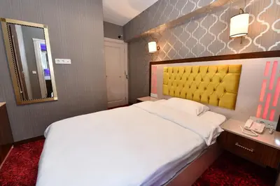 a bedroom with a large white bed and a mirror at Sea Moon Hotel in Istanbul