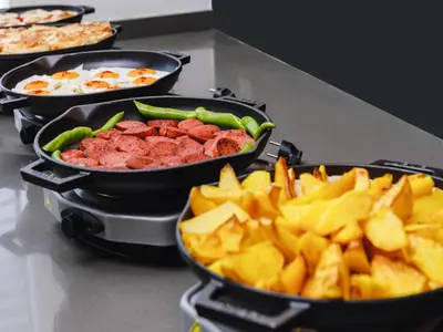 a counter top with three pans of food and chips at Ibis Istanbul Esenyurt in Istanbul