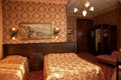 a bedroom with two beds and a painting on the wall at Grand Hotel de Londres in Istanbul