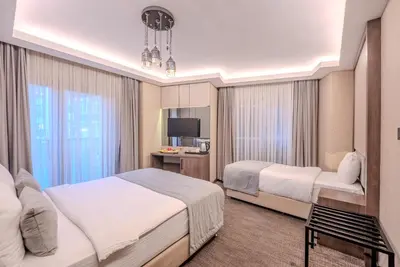 a hotel room with two beds and a tv at BEST GARDEN HOTEL in Istanbul