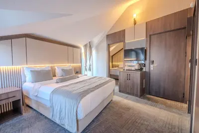 a hotel room with a large bed and a kitchen at BEST GARDEN HOTEL in Istanbul