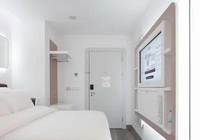 a white bedroom with a bed and a flat screen tv at YOTEL Istanbul Airport, City Entrance in Istanbul