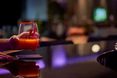 a person holding a glass of orange liquid at YOTEL Istanbul Airport, City Entrance in Istanbul