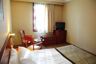a hotel room with a bed and a table and a television at Feronya Hotel in Istanbul