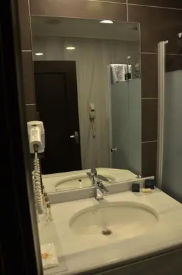 a bathroom with a sink and a phone in a mirror at Sultan Mehmed Hotel in Istanbul