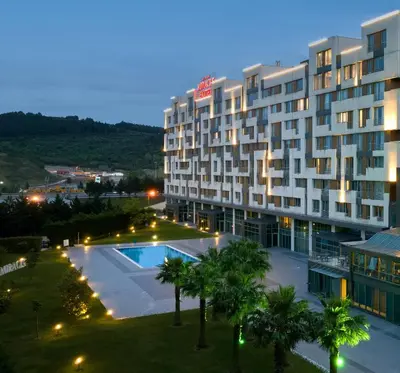 a view of a hotel with a pool and palm trees at Miracle Istanbul Asia Airport Hotel & Spa in Istanbul