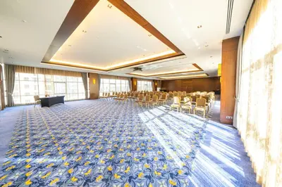 a large room with chairs and a stage in the middle at Miracle Istanbul Asia Airport Hotel & Spa in Istanbul
