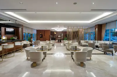 a hotel lobby with tables and chairs and a bar at Miracle Istanbul Asia Airport Hotel & Spa in Istanbul