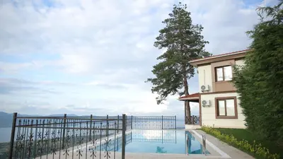 a house with a swimming pool next to a fence at Orchid Hills - heated swimming pool in Sapanca